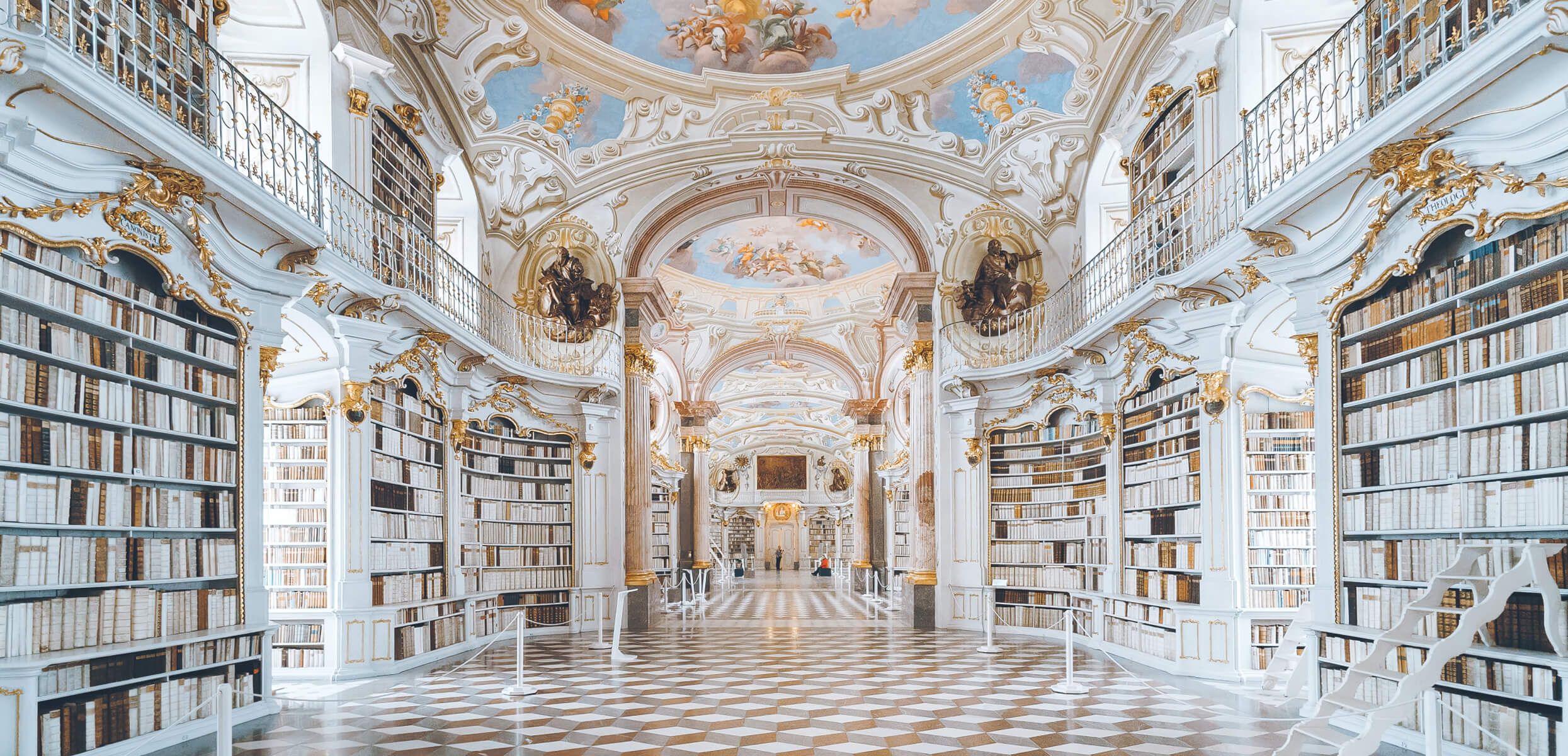 Grand library with marble pillars, gold details, and fresco ceiling