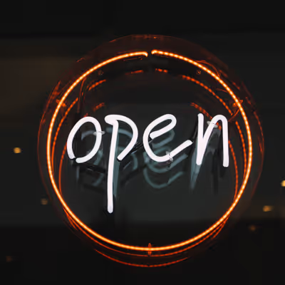 Photo of a glowing circular neon "open" sign